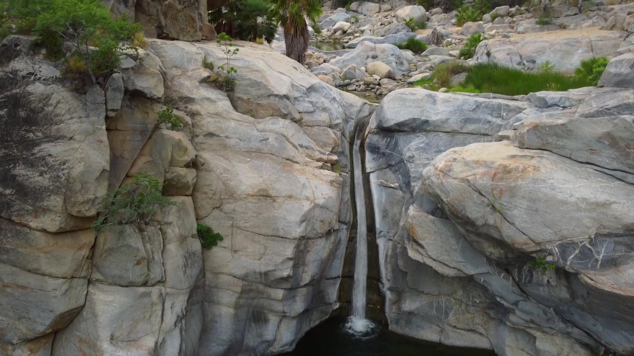 Aerial 4k drone footage capturing the waterfall and unique rock formations at Fox Canyon in Santiago, Los Cabos, Baja California Sur, México.