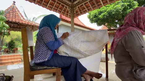 these mothers are making batik using the technique of making hand-drawn batik using a canting tool. these craftsmen make typical giriloyo bantul yogyakarta batik.