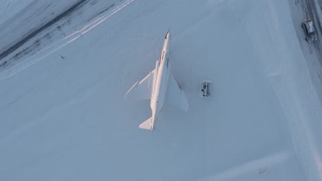 directly above inactive fighter jet with snow as memorial in keflavik, iceland