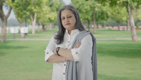 Portrait-of-Confident-Indian-mother-standing-crossed-hands-in-park