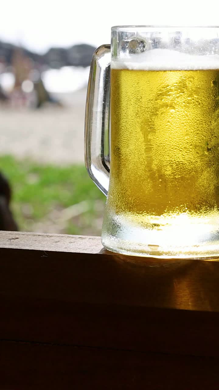 dos tazas de cerveza sonando en una playa soleada