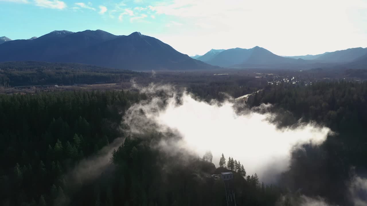 vista aérea escénica de la cascada de snoqualmie durante el hermoso día de verano y la niebla épica que rodea los árboles del bosque
