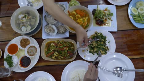 group of people having dinner with thai food, top view on the table