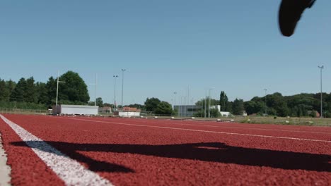 Pies-De-Niño-Trotando-En-La-Pista-De-Atletismo-A-Cámara-Lenta