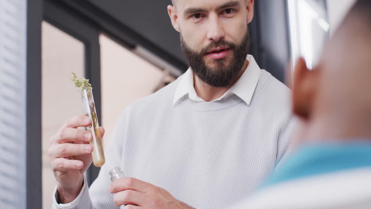 다양한 남성 교사와 학생들이 학교 교실에서 시험관에서 식물을 공부하고 있습니다.