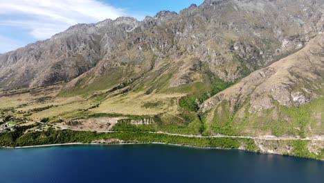 Winding-road-around-Lake-Wakatipu,-high-mountain-scenery,-New-Zealand-landscape