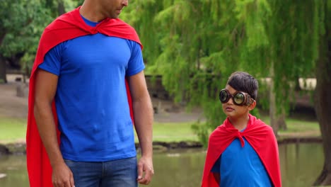 animation of comic icons over happy biracial father with son with superhero costumes