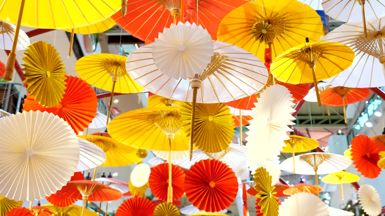 숨막히는 전통적인 다채로운 우산 장식이 줄무 천장에 매달려 있습니다.