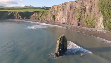 drone dando vueltas en el mar en hidden cove copper coast waterford irlanda en la hora de oro