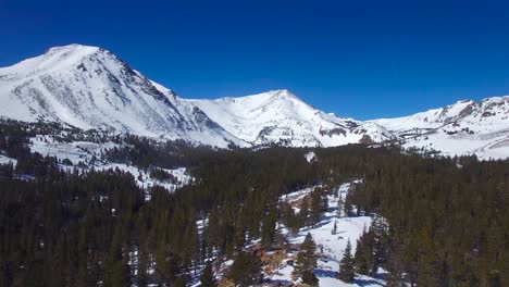 an aerial over a remote abandoned cabin on a mountaintop in the high sierra nevada mountains in winter 2