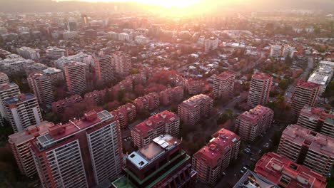 Carretilla-Aérea-En-Edificios-De-Gran-Altura-Del-Barrio-De-Vitacura-A-La-Hora-Dorada-Con-Rayos-De-Sol-En-El-Horizonte,-Santiago,-Chile