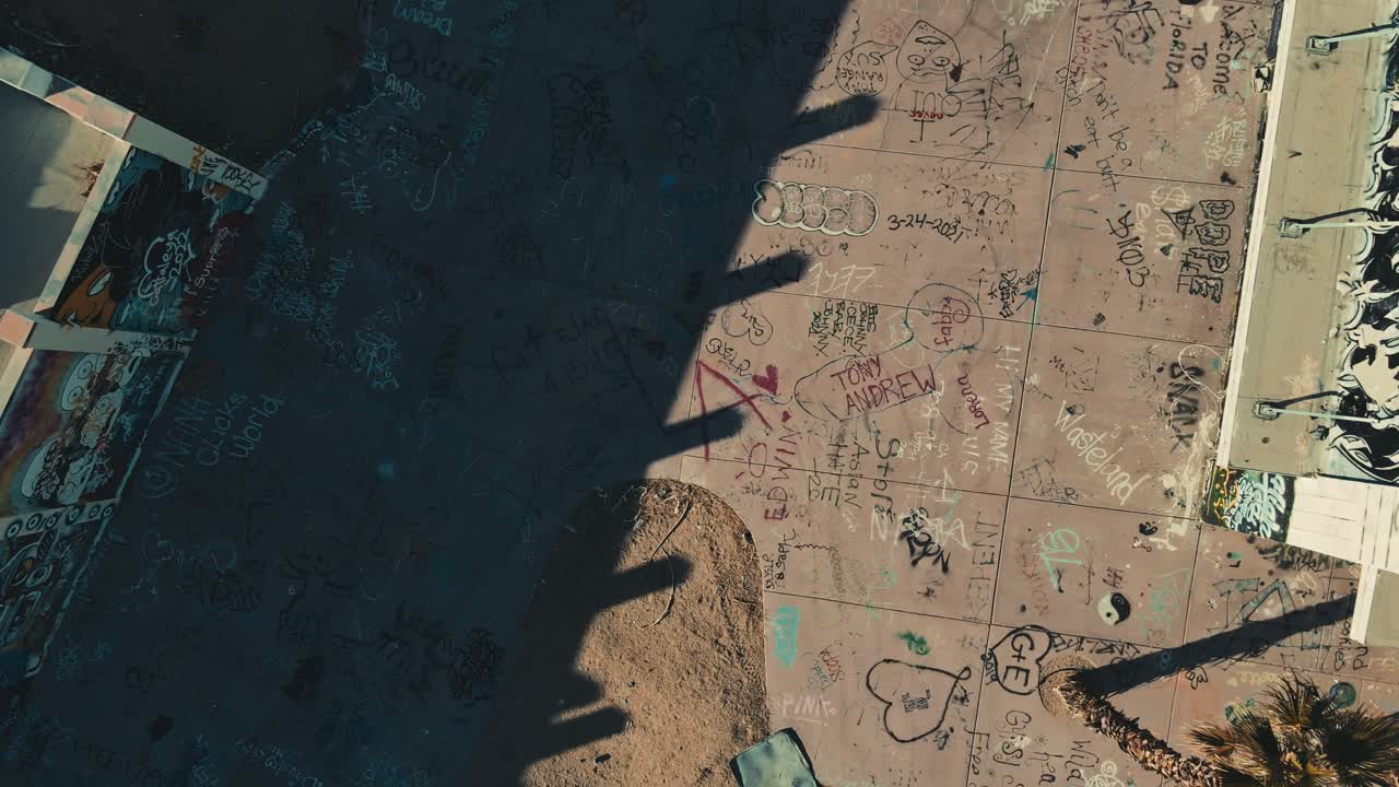 una ripresa aerea di un drone che si allontana per vedere i tetti di edifici abbandonati nel deserto della california.