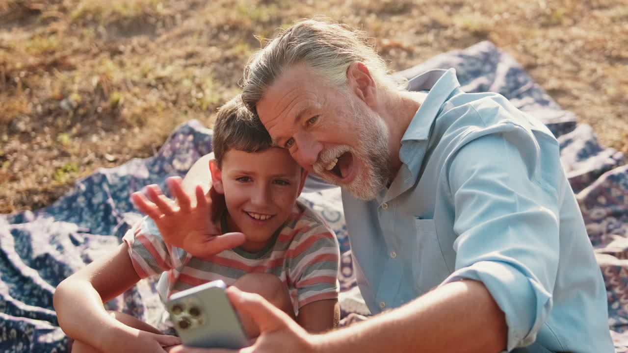 Happy Grandfather and Grandson Taking a Selfie Outdoors