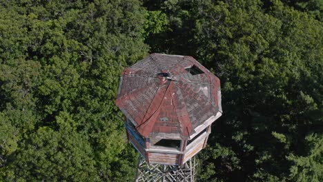 drone looking down at fire lookout tower in the middle of wooded area in canada