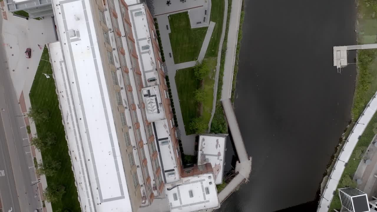 video de un avión no tripulado mirando hacia abajo a la sede del fondo de accidentes, el río grand y la pasarela peatonal en lansing, michigan