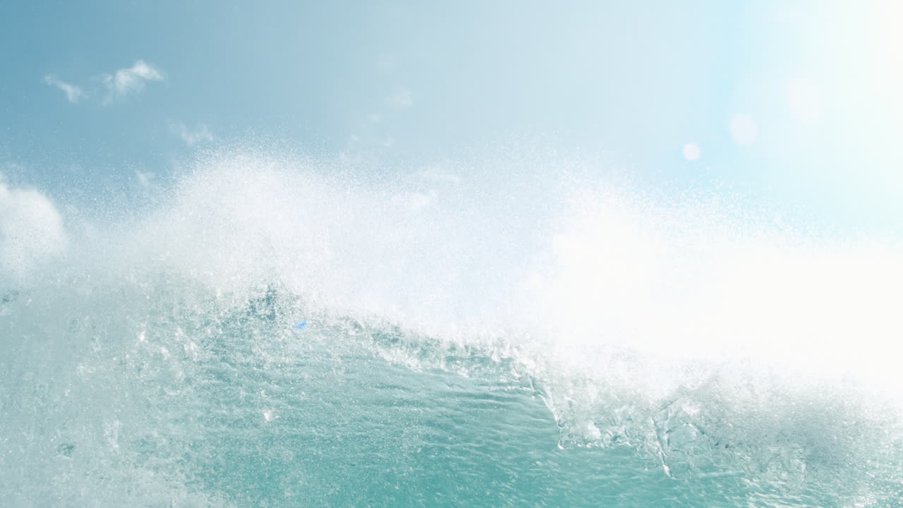Underwater establishinglooking up at turquoise wave rolling above in slow motion