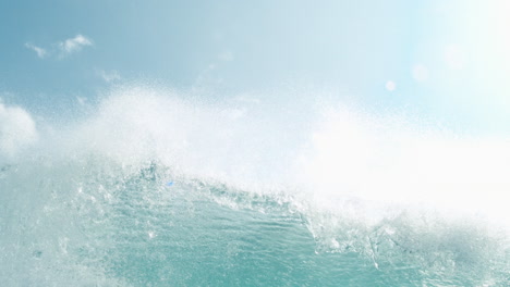 underwater establishinglooking up at turquoise wave rolling above in slow motion