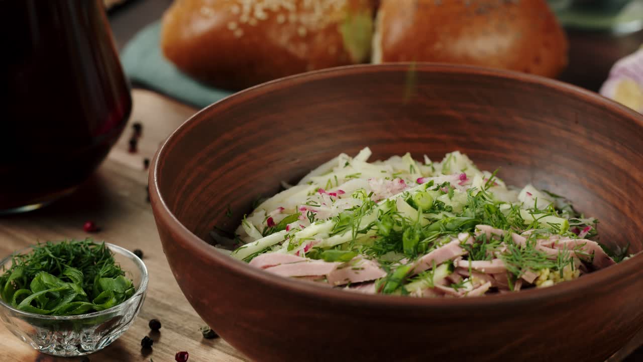 Ajout d'aneth frais et d'oignons verts à une salade estivale.