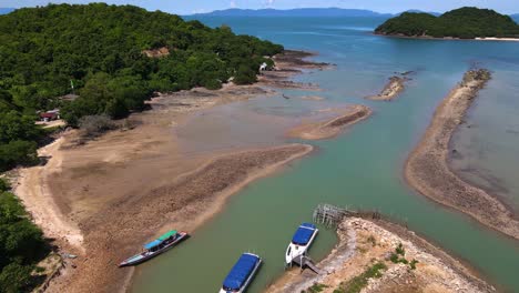 Tilt-up-view-of-boats-standing-in-a-sandy-sea-coast-of-random-Island-near-Koh-Samui,-Thailand