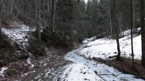 Estrecho-Río-Congelado-En-El-Bosque-De-Invierno---Tiro-Panorámico