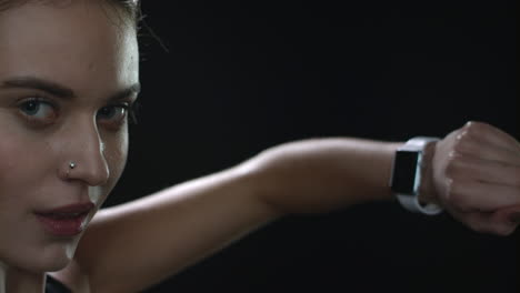 Sport-woman-touching-smart-watch-screen-on-black-background