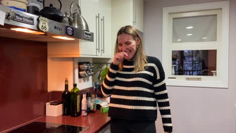 Caucasian-pretty-blonde-young-woman-laughing-loudly-in-the-home-kitchen