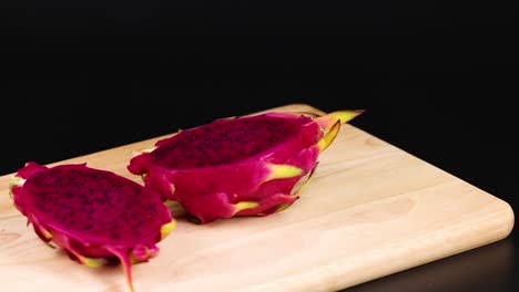 dragon fruit halves displayed on a wooden board