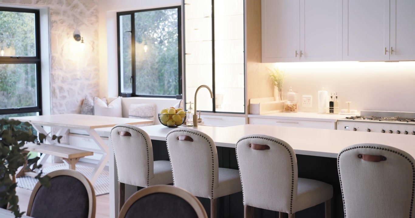 Slow camera is panning from left window, revealing kitchen island and stools to showcase design