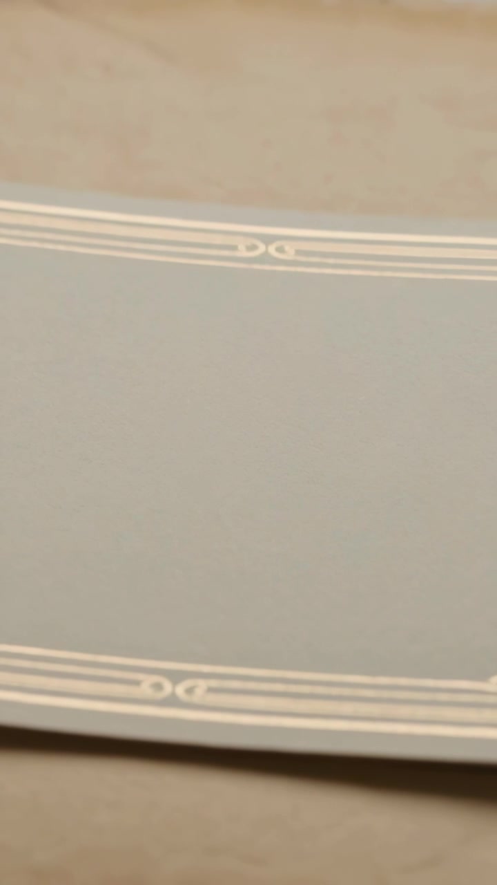Vertical video: Shifting camera revealing rectangular panel on wooden tabletop, showing pale border
