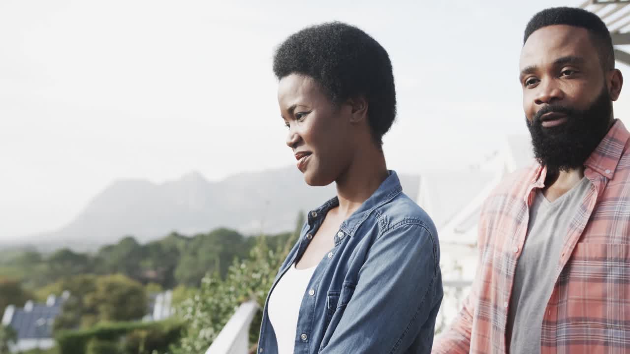 행복한 아프리카계 미국인 커플이  ⁇ 은 테라스에서 포옹하고, 슬로우 모션