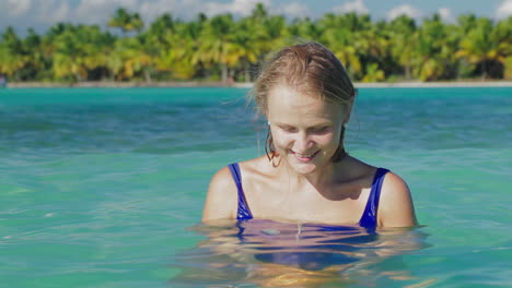 Mujer-Sonriente-En-Agua-De-Mar-Con-Estrellas-De-Mar