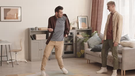 cheerful young man watching his boyfriend dancing for him