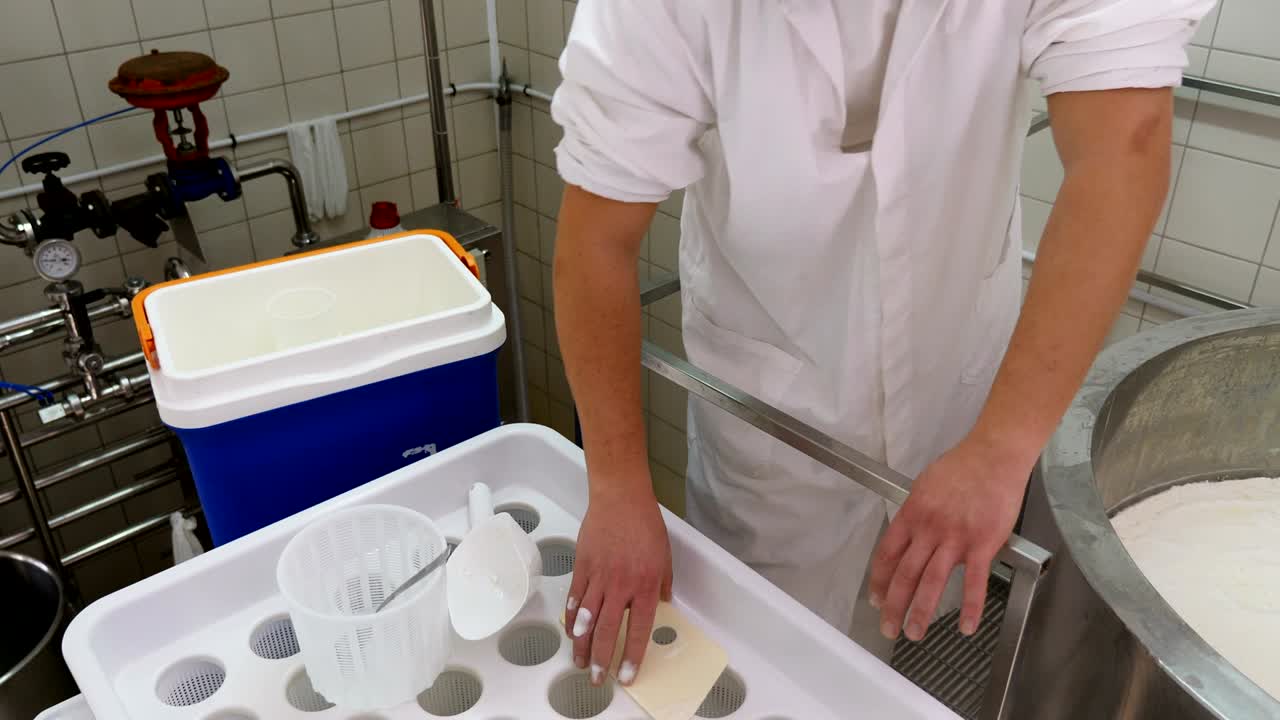 diary man putting cheese in the molds- Cheese production