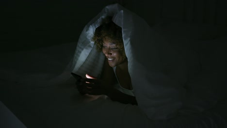 young woman using phone in dark room