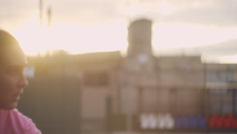 a young girl at a tennis practice hits a serve with a forehand. training at sunset. medium shot