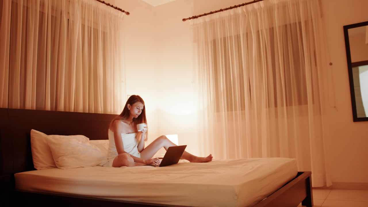 밤에 침대에서 노트북으로 일하는 여자