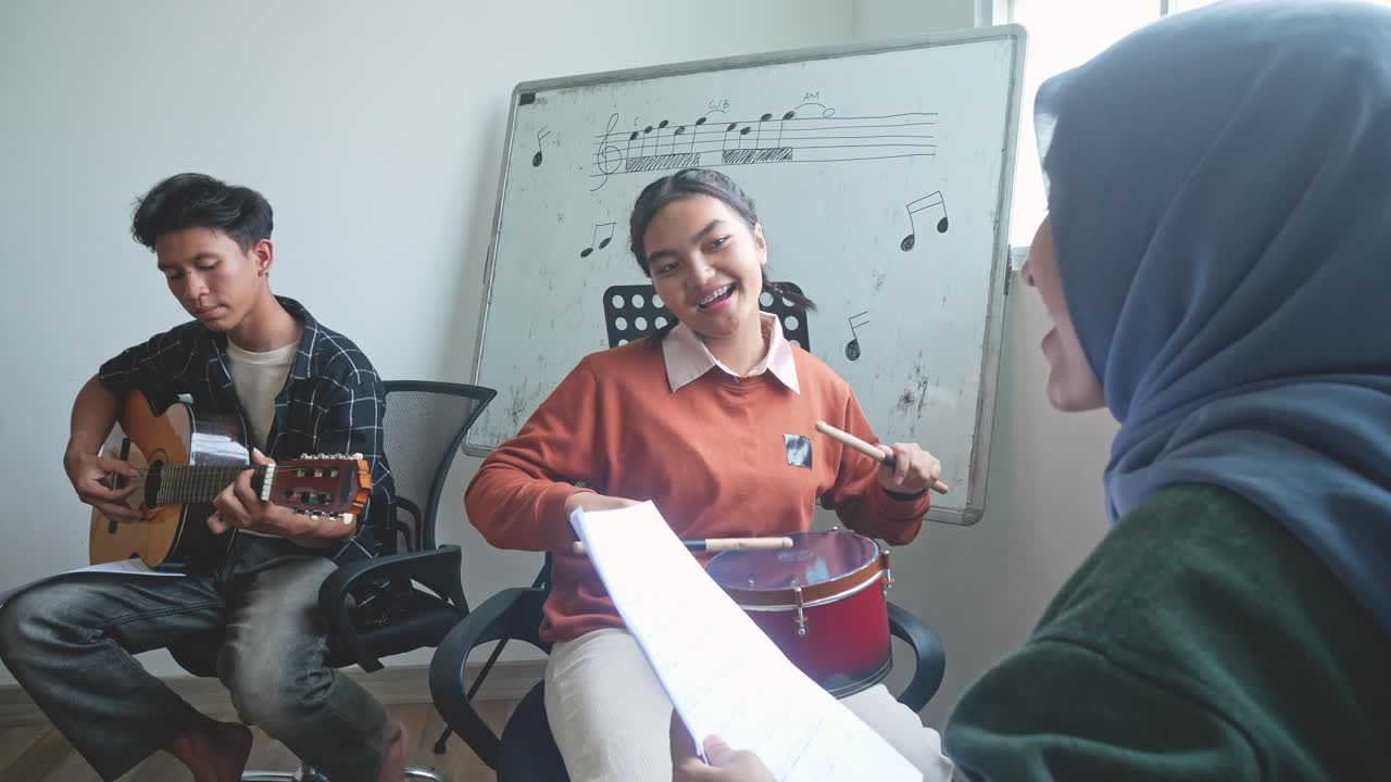 Multiethnic Of Asian Students Practicing Singing And Playing Musical Instruments In Class