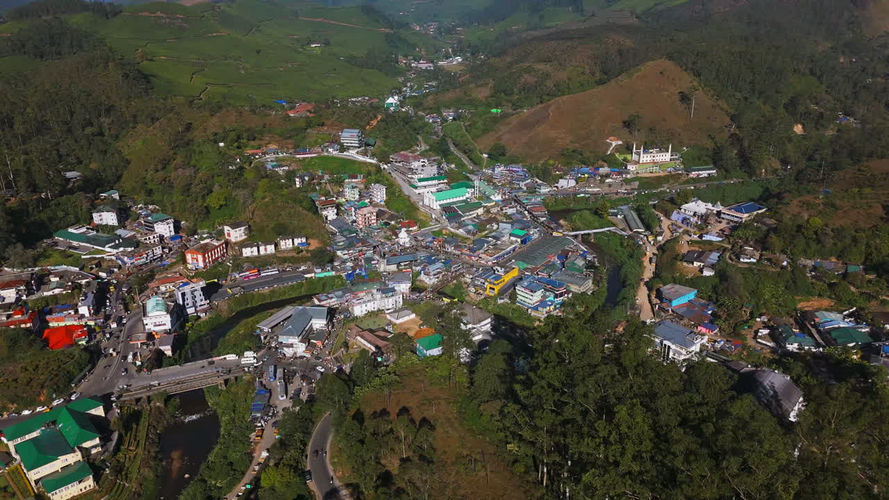 Aerial tracking shot overlooking streets of the Munnar village, in Kerala, India