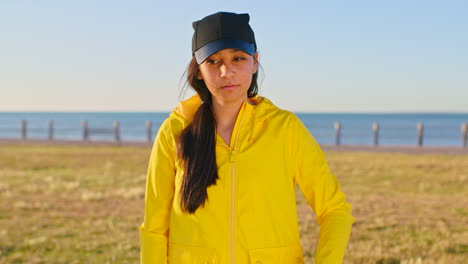 young woman in yellow raincoat at the beach