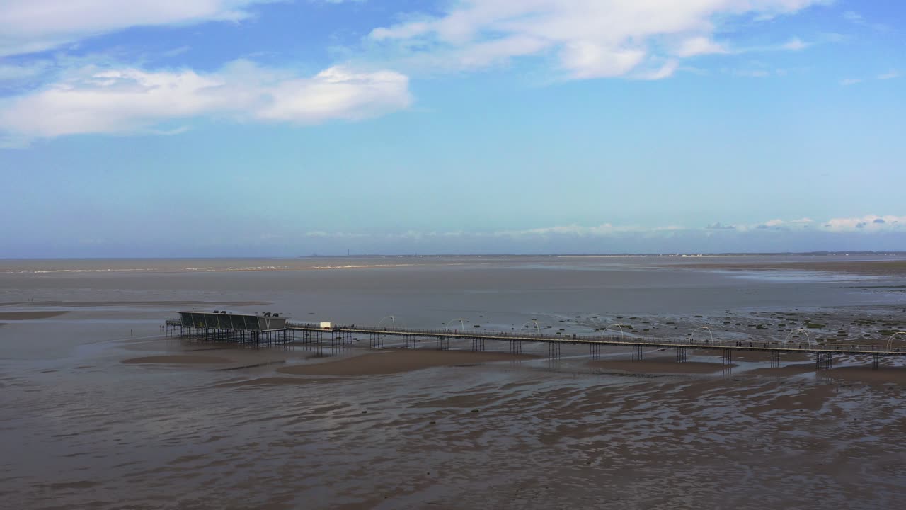 Aerial drone view of Southport Pier revealing panoramic landscape of empty beach.