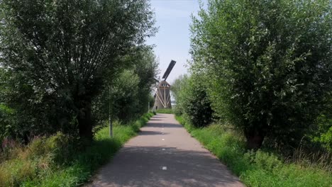 scenic bike path leading to a windmill in the netherlands