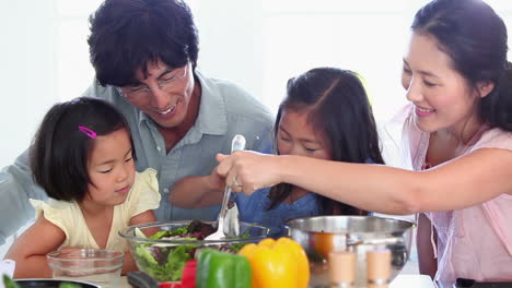 family preparing a salad together