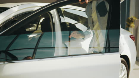 man opening car door at dealership