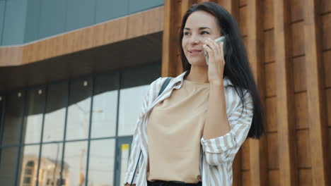 woman talking on phone outside modern building