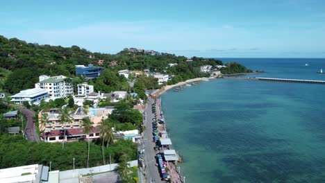 Small-town-on-the-coast-of-Phuket-Island-and-the-Andaman-Sea,-Aerial-pan-right