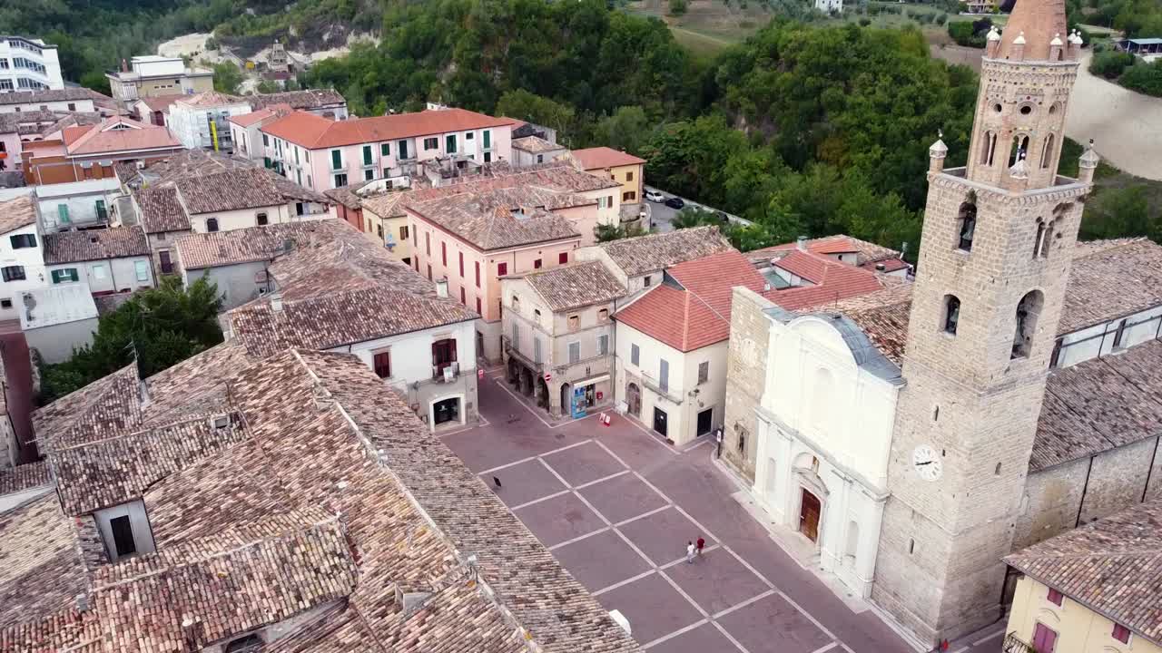 toma aérea de un campanario en una plaza de una pequeña ciudad italiana