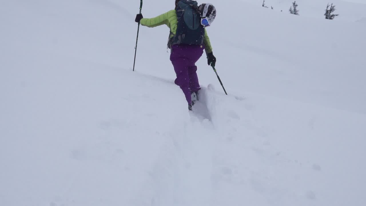 Scialpinista che sale attraverso neve fresca profonda