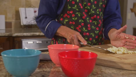 manos de la mujer moviendo verduras picadas en cuencos para cocinar con