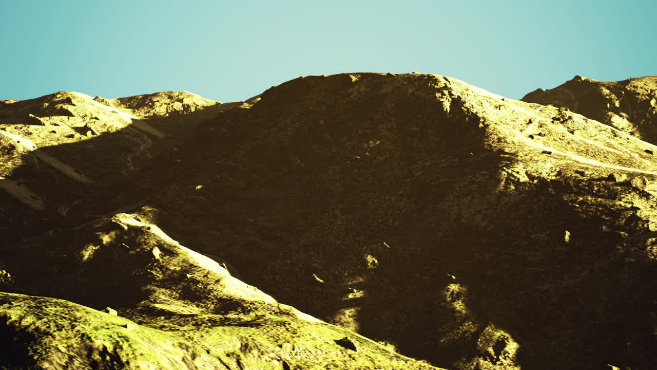 Mountains basking in sunlight under a clear sky during midday hours