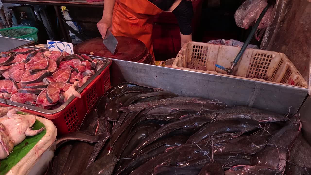 Vendeur disposant des fruits de mer sur un étal de marché animé